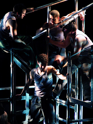 Close up of three figures sitting and leaning at the top of the scaffold above young Jacques sitting in the centre.